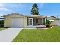 Charming home features a garage, screened lanai, and well-maintained lawn and landscaping at 3716 Carioca Rd, Holiday, FL 34691