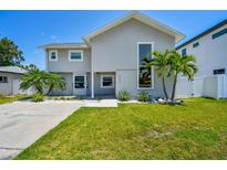 Charming two-story home featuring a well-manicured lawn, palm trees, and modern architectural details at 3801 Huntington Ne St, St Petersburg, FL 33703