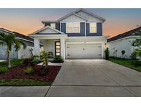 Charming two-story home featuring a well-manicured lawn, covered porch and a two car garage at 5437 Del Coronado Dr, Apollo Beach, FL 33572