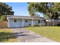 Charming single-story home featuring a well-maintained lawn and inviting front porch at 5932 Mckee Lake N Dr, St Petersburg, FL 33709