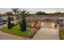 Charming single-story home featuring a well-manicured lawn, mature landscaping, and a driveway leading to an attached garage at 7534 Culberson Dr, Port Richey, FL 34668