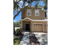 Charming two-story home featuring a front-entry garage and covered porch at 10402 Tulip Field Way, Riverview, FL 33578