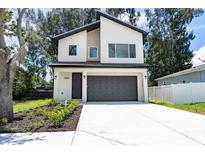 Modern two-story home featuring a gray garage door, well-manicured landscaping and a light-colored exterior at 12484 Cross St, Largo, FL 33773