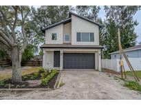 Contemporary two-story home featuring a two-car garage and minimalist landscaping at 12484 Cross St, Largo, FL 33773
