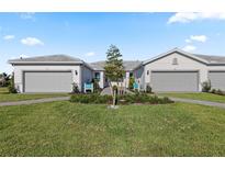 Charming villa exterior showcasing a well-maintained lawn and inviting curb appeal under a bright blue sky at 14313 Eagle Branch Dr, Nokomis, FL 34275