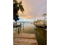 Scenic waterfront view with a rainbow, docks, boats, and calm waters creating a serene and inviting atmosphere at 14555 N Bayshore Dr, Madeira Beach, FL 33708