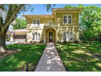 Inviting exterior elevation showcasing manicured lawn and elegant architectural details on a sunny day at 1940 Floresta View Dr, Tampa, FL 33618