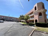 Exterior view of building with balconies and a parking lot at 2457 Ecuadorian Way # 57, Clearwater, FL 33763
