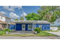Charming single-story home featuring a bright blue exterior, covered parking, and well-maintained landscaping at 297 Lakeview Dr, Tarpon Springs, FL 34689