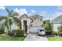 Beautiful two-story home featuring an attached two-car garage, well-maintained landscaping, and a welcoming entrance at 30817 Pumpkin Ridge Dr, Wesley Chapel, FL 33543