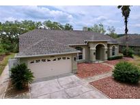 Charming single-story home featuring a manicured lawn, two-car garage, and inviting front entryway at 5058 Westlake Blvd, Dade City, FL 33523