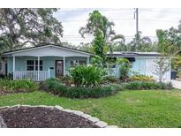 Inviting single-story home featuring a front porch, manicured front yard landscaping and a private driveway and garage at 7842 15Th N Way, St Petersburg, FL 33702