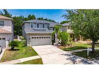 Inviting two-story home featuring a spacious driveway, attached two-car garage, and well-manicured landscaping at 10636 Dawns Light Dr, Riverview, FL 33578