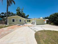 Charming one-story home with a palm tree, wide driveway, and inviting curb appeal on a sunny day at 1101 Alcazar S Way, St Petersburg, FL 33705