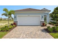 Garage and patterned driveway in front of a two-car garage with manicured landscaping at 11375 Boundless Ter, Venice, FL 34293
