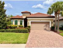 Charming home boasts a red tile roof, manicured lawn, and inviting two-car garage at 11489 Bitola Dr, Odessa, FL 33556