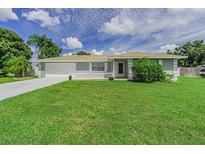 Charming single-story home with a well-manicured lawn, white picket fence, and attached two car garage at 1829 1St E Ave, Bradenton, FL 34208