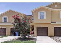 Charming townhome with a well-maintained lawn and a beautiful flowering tree in front of the property at 1984 Hawks View Dr, Ruskin, FL 33570