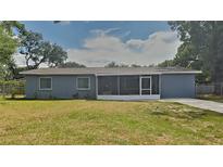 Charming single-story home with a screened-in porch and a well-maintained front lawn at 2105 Oakview Ln, Plant City, FL 33566