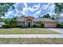 Charming single-story home featuring a stucco exterior, arched windows, and a well-maintained front yard at 2117 Laindale Pl, Valrico, FL 33596