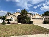 Charming single-story home with mature landscaping and a two-car garage at 2213 Towering Oaks Cir, Seffner, FL 33584