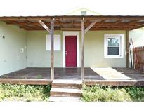 Charming home featuring a covered front porch with a bright red front door at 3412 N 54Th St, Tampa, FL 33619