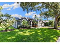 Beautifully landscaped home featuring lush lawn and mature trees at 4690 Wrentham Pl, Palm Harbor, FL 34685