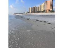 Expansive beachfront view with pristine white sand and luxury condominiums in the background at 880 Mandalay Ave # S302, Clearwater Beach, FL 33767