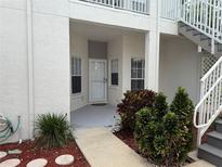 Inviting front entrance with white door, landscaping and staircase to upper level at 11351 Shipwatch Ln # 1844, Largo, FL 33774