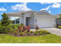 Charming home with a well-manicured front yard, a paver driveway, and a two-car garage at 11470 Myakka Blue Dr, Venice, FL 34293