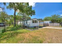 Quaint single-story home with mature trees, fenced yard, and a convenient carport at 11940 Terra Ceia Ave, New Port Richey, FL 34654