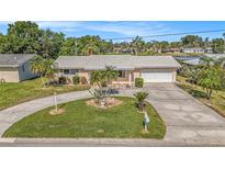 Charming single-story home with mature landscaping, circular driveway, and attached garage at 12848 137Th Ln, Largo, FL 33774