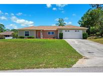 Inviting single-story home with a manicured lawn and a two-car garage at 13040 Hanley Dr, Spring Hill, FL 34609