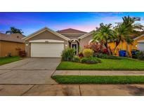 Charming single-story home featuring a well-manicured lawn, mature palm trees, and an attached two-car garage at 1535 Crossvine Ct, Trinity, FL 34655