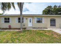 Charming single-story home with a well-maintained lawn, tidy landscaping, and neutral painted exterior at 1980 Taylor Lake Cir, Largo, FL 33778
