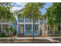 Charming two-story home with a welcoming front porch, blue exterior, and a manicured front yard at 2130 W Spruce St, Tampa, FL 33607