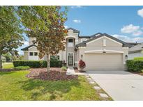 Charming two-story home featuring manicured landscaping and a spacious two-car garage at 21834 Southern Charm Dr, Land O Lakes, FL 34637