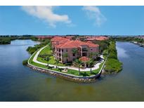 Stunning aerial view of waterfront condos with red tile roofs and lush landscaping in a beautiful community at 2755 Via Capri # 1223, Clearwater, FL 33764