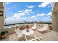 A stunning view of a balcony furnished with comfortable lounge chairs overlooking the water at 4 Belleview Blvd # 802, Belleair, FL 33756