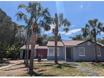 Charming single-story home with palm trees in the front yard at 627 Riverside Dr, Tarpon Springs, FL 34689
