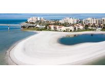 Stunning aerial view of beachfront condos with white sandy beach and blue ocean waters at 845 S Gulfview Blvd # 107, Clearwater Beach, FL 33767