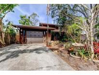 Charming home exterior with mature landscaping and a two-car garage at 919 Sandpiper S Way, St Petersburg, FL 33707