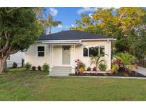 Charming single-story home with inviting front porch and landscaped front yard at 1443 Paloma Ln, Dunedin, FL 34698