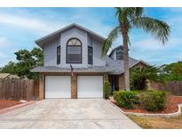 Charming two-story home featuring a two-car garage, landscaped yard, and beautiful architectural details at 3177 Montrose Pl, Palm Harbor, FL 34684