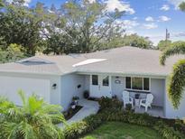 Charming single-story home featuring a well-manicured lawn, cozy porch seating, and lush, mature landscaping at 5235 42Nd S St, St Petersburg, FL 33711
