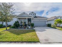 Charming single-story home with well-manicured lawn, blue accents and attached two car garage at 5538 Spanish Moss Cv, Bradenton, FL 34203