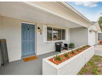 Charming front porch with seating area, planter, and stylish blue front door at 5620 Perkin Dr, New Port Richey, FL 34652