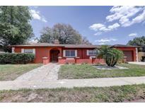 Inviting home with manicured lawn, walkway, and welcoming front entrance at 7117 Wrenwood Cir, Tampa, FL 33617