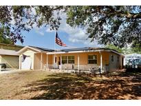 Charming single-story home featuring a front porch, tidy landscaping and an American flag at 8039 83Rd N St, Seminole, FL 33777