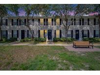 Charming townhome exterior with manicured lawn and bench seating area at 9506 Harpender Way, Tampa, FL 33626